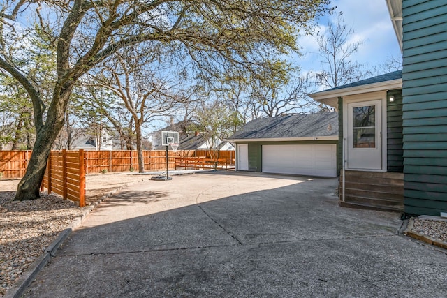 view of patio / terrace featuring entry steps, a detached garage, and fence