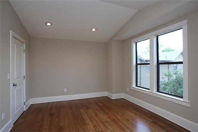 empty room featuring recessed lighting, dark wood-style flooring, vaulted ceiling, and baseboards