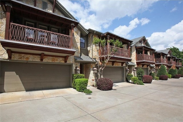 view of front of property featuring stone siding, concrete driveway, and an attached garage