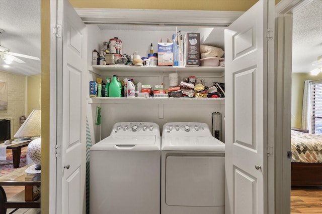 clothes washing area with laundry area, ceiling fan, washer and clothes dryer, and wood finished floors