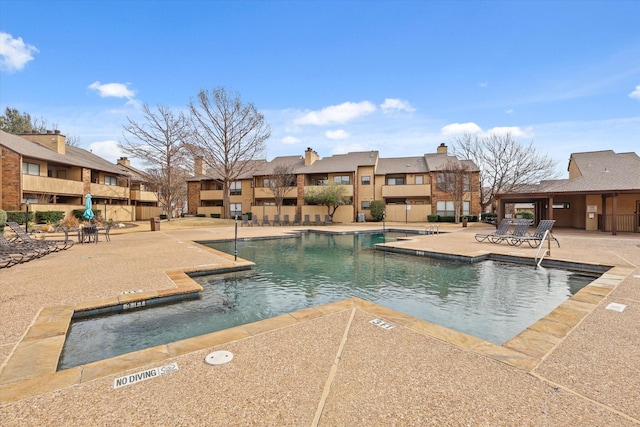 pool featuring a patio area and a residential view