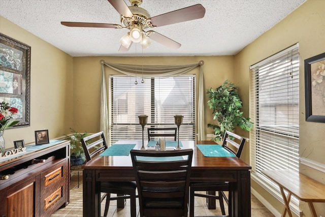 dining space with a healthy amount of sunlight, a ceiling fan, and a textured ceiling