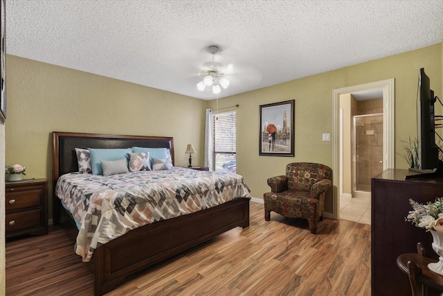 bedroom with ensuite bathroom, a ceiling fan, a textured ceiling, wood finished floors, and baseboards