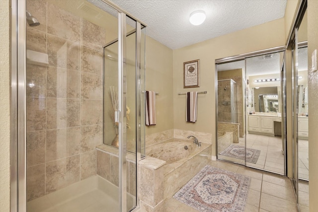 full bathroom featuring a stall shower, tile patterned floors, a garden tub, a textured ceiling, and vanity