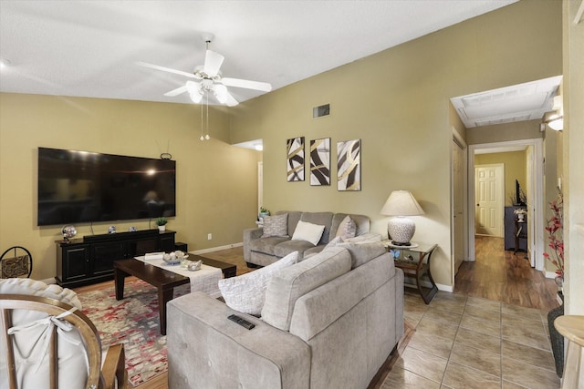 tiled living area with visible vents, ceiling fan, and baseboards