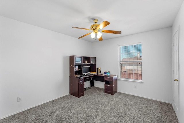 carpeted office featuring a ceiling fan and baseboards