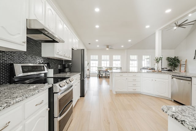 kitchen featuring white cabinets, a ceiling fan, decorative backsplash, appliances with stainless steel finishes, and under cabinet range hood