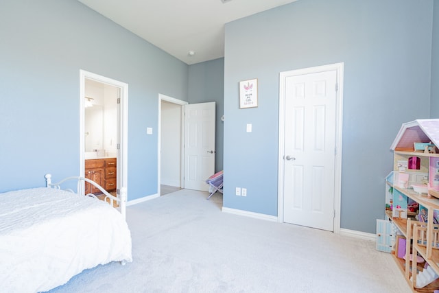 bedroom with baseboards, ensuite bath, and light colored carpet