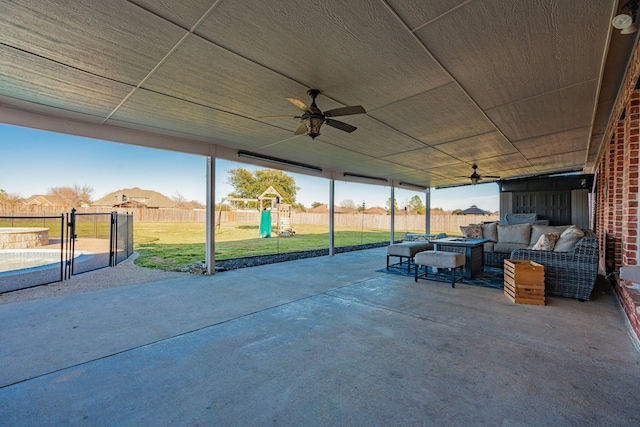 view of patio / terrace with ceiling fan, a fenced backyard, outdoor lounge area, and a playground