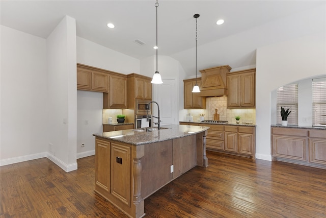 kitchen featuring dark stone countertops, visible vents, dark wood-style flooring, custom range hood, and appliances with stainless steel finishes