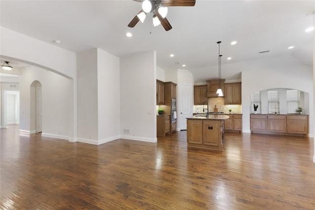 unfurnished living room with visible vents, recessed lighting, arched walkways, dark wood-style floors, and a ceiling fan