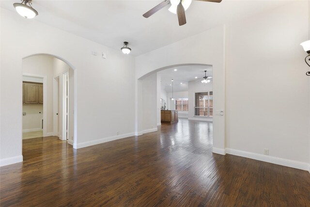 interior space featuring baseboards, dark wood finished floors, recessed lighting, arched walkways, and ceiling fan