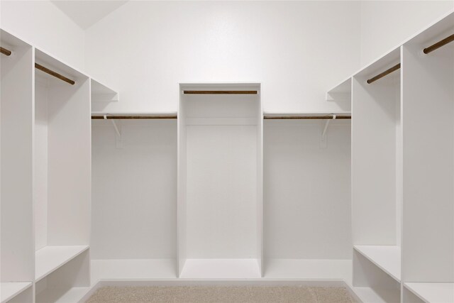 full bath featuring a spacious closet, vanity, and baseboards