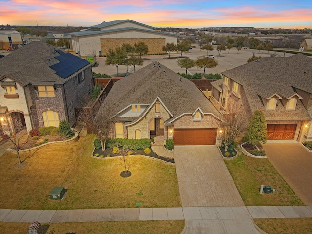 view of front of property featuring a garage, a residential view, brick siding, and driveway