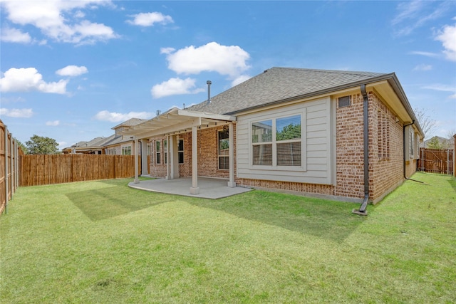 rear view of property featuring a patio, roof with shingles, a fenced backyard, a lawn, and brick siding