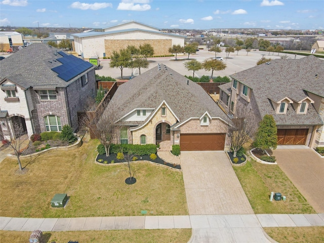 view of front of house with brick siding, a residential view, concrete driveway, roof with shingles, and a garage