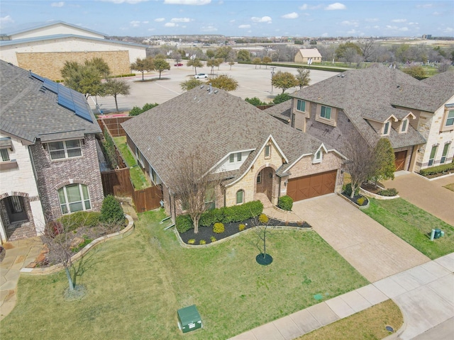 view of front of home with a residential view, roof with shingles, concrete driveway, a garage, and brick siding