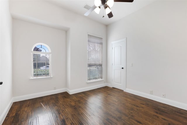 empty room featuring a ceiling fan, visible vents, wood finished floors, and baseboards