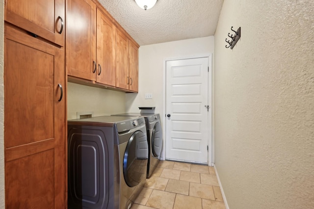 clothes washing area with cabinet space, a textured wall, a textured ceiling, and washing machine and clothes dryer