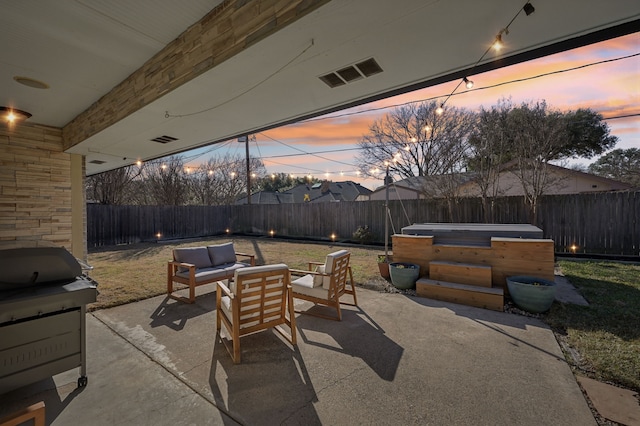 patio terrace at dusk featuring visible vents, a jacuzzi, a fenced backyard, grilling area, and an outdoor living space