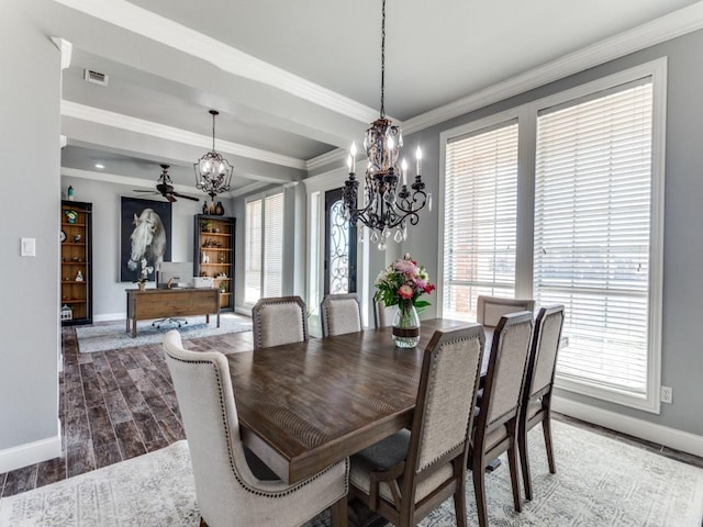 dining room with wood finish floors, crown molding, a notable chandelier, visible vents, and baseboards