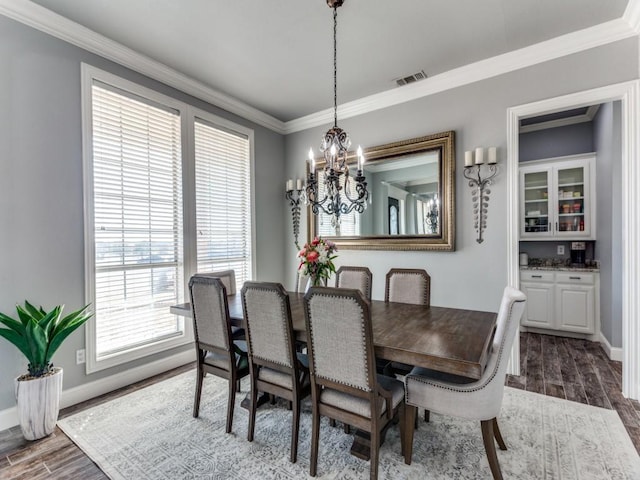 dining space with baseboards, visible vents, dark wood-type flooring, and ornamental molding