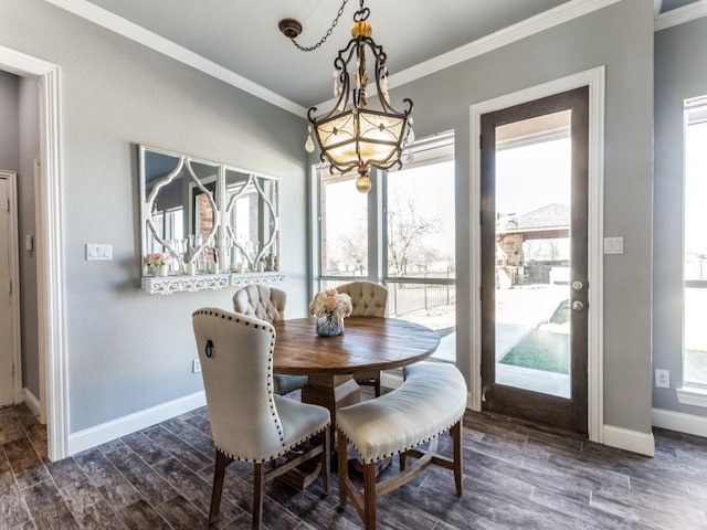 dining room with dark wood-type flooring, a notable chandelier, crown molding, and baseboards