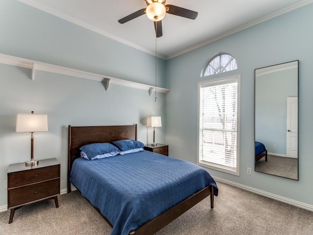 carpeted bedroom with crown molding, baseboards, and ceiling fan