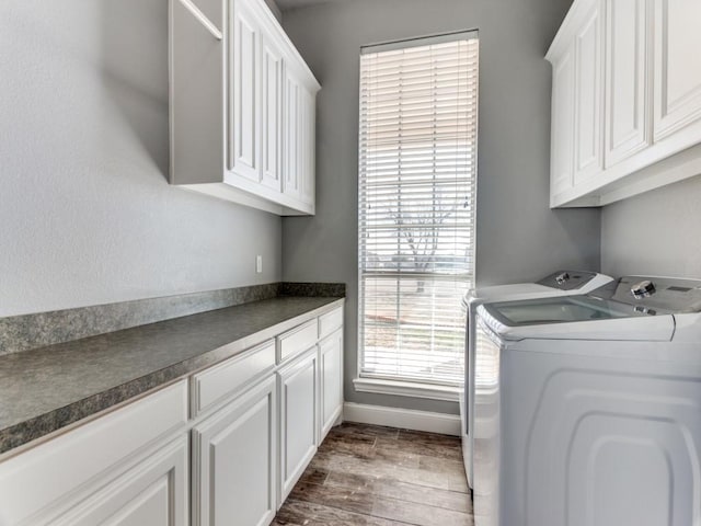 washroom featuring cabinet space, baseboards, dark wood-style floors, and separate washer and dryer