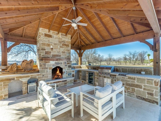 view of patio / terrace with an outdoor stone fireplace, area for grilling, a grill, and a gazebo