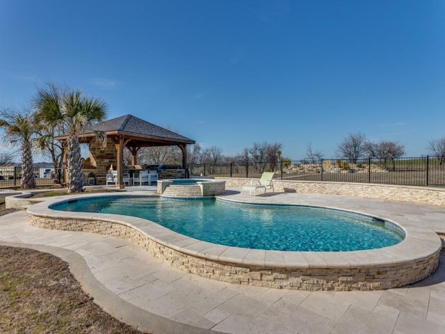 view of pool featuring a pool with connected hot tub, a patio area, fence, and a gazebo