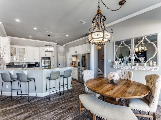 dining space featuring visible vents, ornamental molding, dark wood-type flooring, an inviting chandelier, and recessed lighting