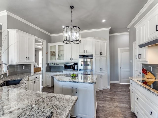 kitchen featuring dark wood finished floors, appliances with stainless steel finishes, glass insert cabinets, white cabinets, and a sink