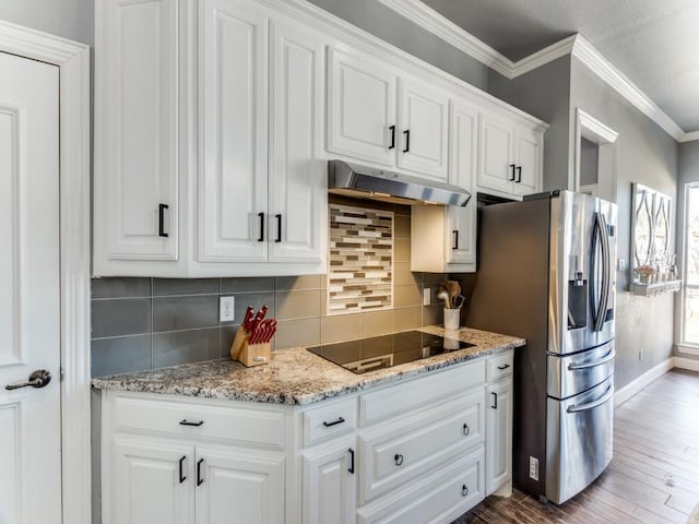 kitchen featuring decorative backsplash, black electric stovetop, crown molding, under cabinet range hood, and white cabinetry