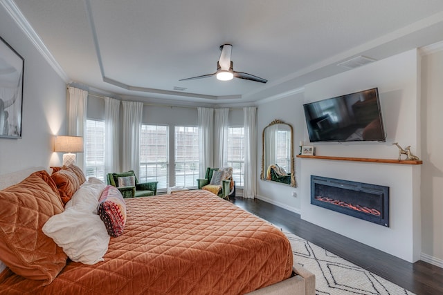 425 Brook Meadow Dr, Midlothian, TX 76065 - bedroom with a tray ceiling, wood finished floors, a glass covered fireplace, baseboards, and a ceiling fan