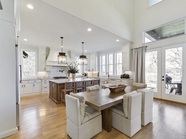 dining space with a chandelier, french doors, light wood-type flooring, and recessed lighting