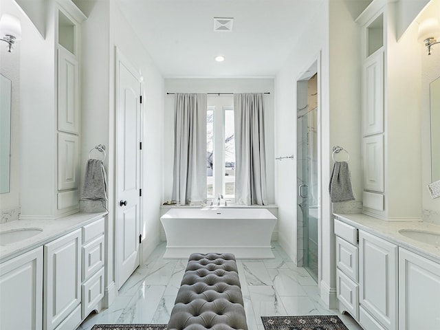 full bath with a freestanding tub, two vanities, visible vents, marble finish floor, and a stall shower