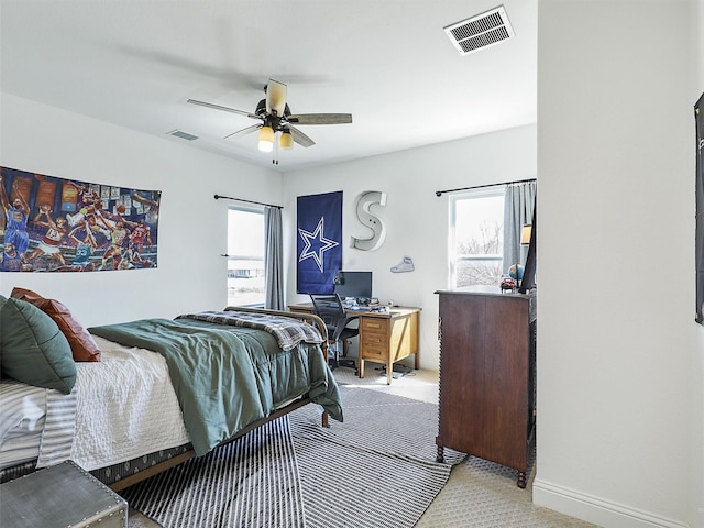 bedroom with light colored carpet, visible vents, ceiling fan, and baseboards