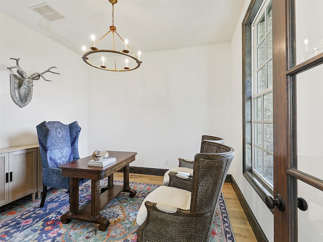 office space with baseboards, a notable chandelier, visible vents, and wood finished floors