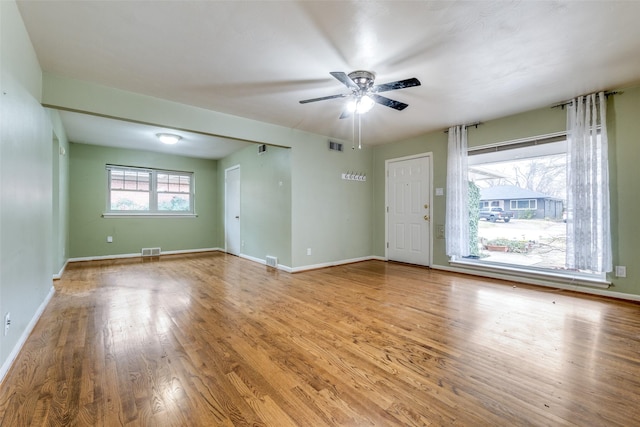 spare room with visible vents, ceiling fan, baseboards, and wood finished floors