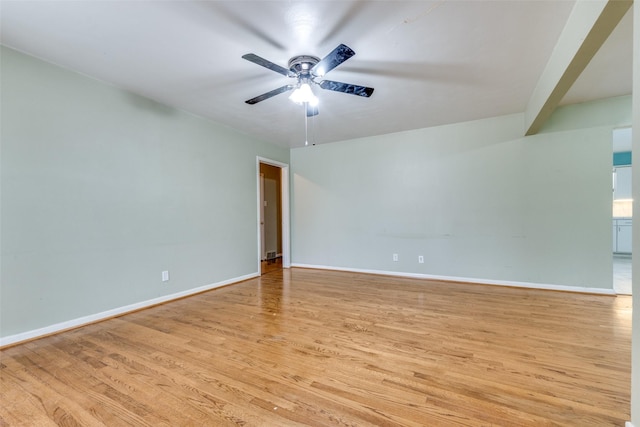 spare room featuring light wood-type flooring, baseboards, and a ceiling fan