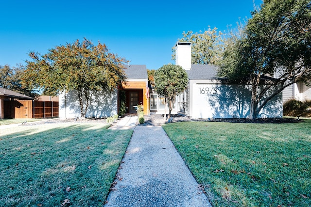 view of front of property with fence and a front lawn