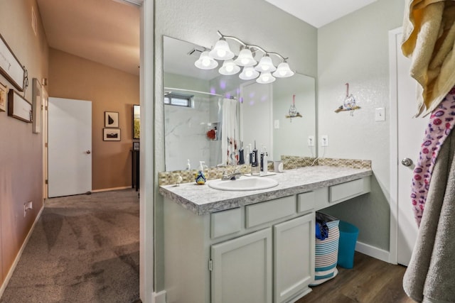 bathroom featuring curtained shower, vanity, and baseboards