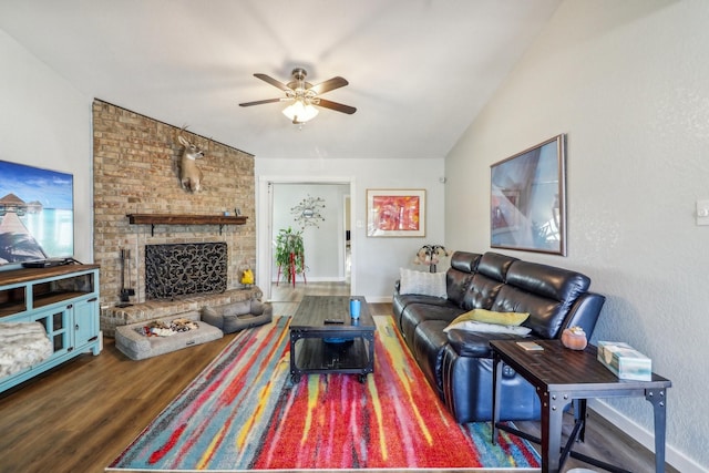 living area featuring ceiling fan, wood finished floors, baseboards, vaulted ceiling, and a brick fireplace