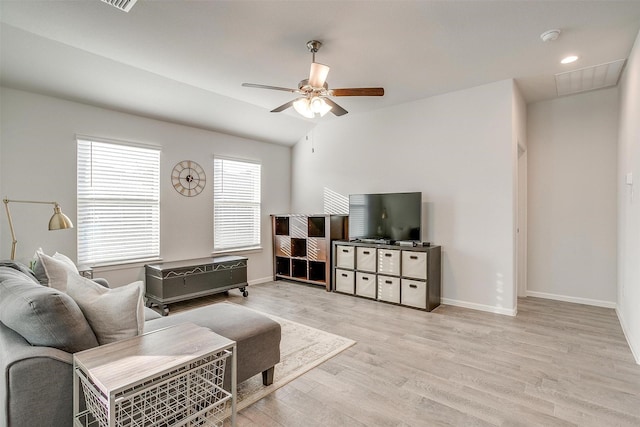 living area featuring baseboards, a ceiling fan, lofted ceiling, light wood-style floors, and recessed lighting