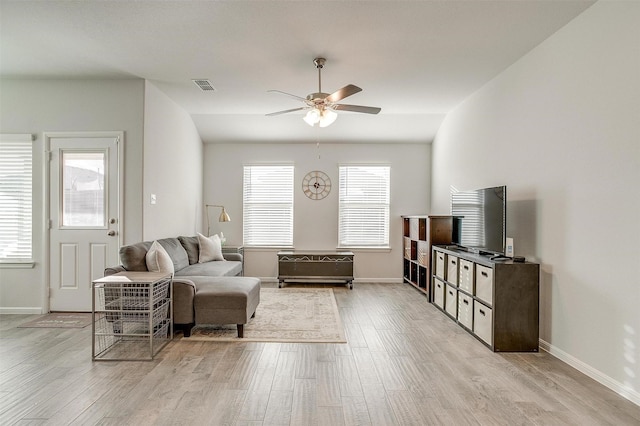 living area with a ceiling fan, visible vents, light wood-style flooring, and baseboards