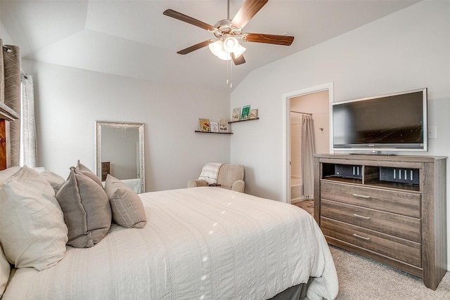 bedroom with a ceiling fan, vaulted ceiling, carpet flooring, and ensuite bathroom