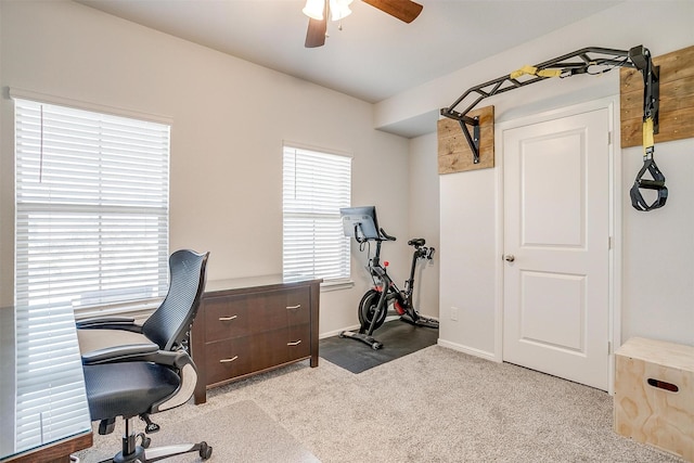 carpeted office featuring a ceiling fan and baseboards