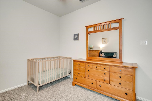 carpeted bedroom featuring a nursery area, visible vents, and baseboards