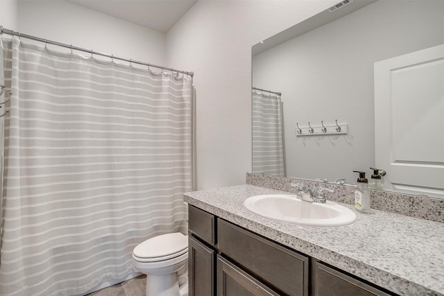 full bath featuring visible vents, vanity, and toilet